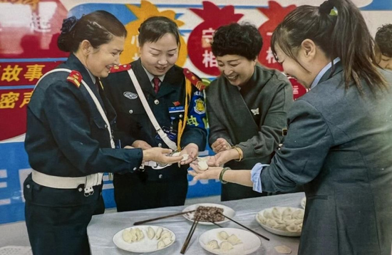 曹爱华和公司各族员工一起包饺子。受访者提供。e