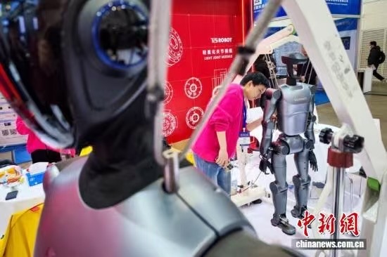 3月18日，天津，工作人员调试人形机器人。当日，第22届中国（天津）国际装备制造业博览会在国家会展中心（天津）启幕。本届天津工博会以“工业数智转型赋能绿色发展”为主题，汇聚了近800家海内外知名企业参展，设置了机床、机器人、自动化、人工智能、算力基础设施与应用、电子、焊接及切割等展区，集中展示各领域的最新技术、产品和解决方案。中新社记者 佟郁 摄