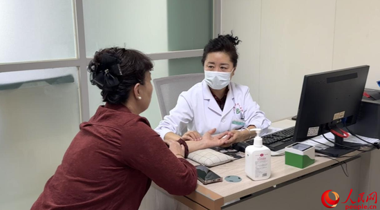 党外知识分子、副主任医师阿达来提·艾依沙坐诊。人民网 娜地拉摄e