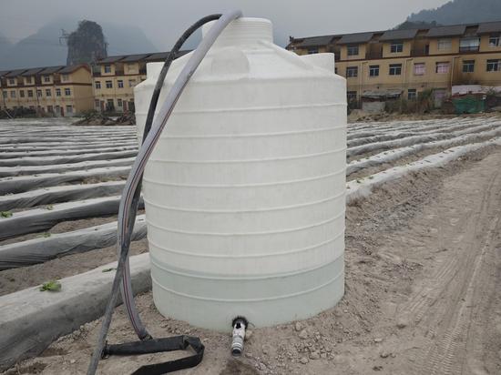 图为烟田新配置的蓄水桶。陆震摄