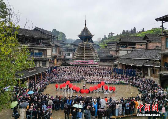 3月22日，2026年贵州省春季“村歌”——黔东南州从江县小黄村示范展示活动举行，千余名侗族群众身着盛装，在素有“侗族大歌之乡”美誉的小黄村鼓楼前唱响《蝉之歌》《布谷催春》等经典侗族大歌，无指挥、无伴奏的多声部合唱与山间春雨交织，现场还进行了琵琶歌、芦笙、多耶舞等民俗表演，吸引众多游客前来观赏。图为侗族群众在小黄村鼓楼前演唱侗族大歌。卢忠南 摄