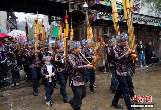 图为侗族群众吹着芦笙在进行巡游。卢忠南 摄