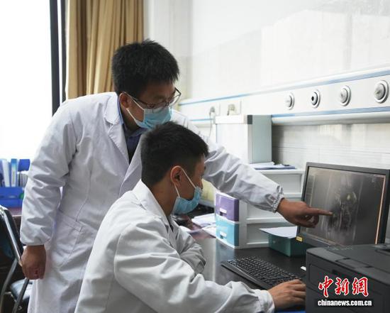 图为重庆市人民医院派驻专家张光钢在赫章县人民医院给当地医生讲解病例。记者 周燕玲 摄