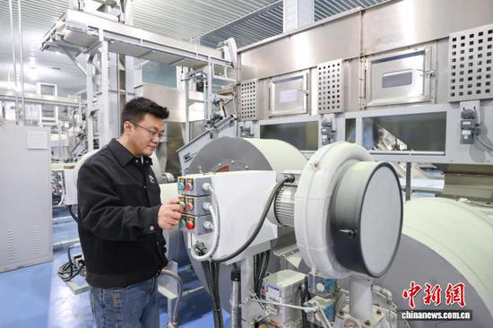 3月24日，贵州凤冈“茶三代”任羿铭在调试新安装的碾茶生产线设备。中新社记者 瞿宏伦 摄