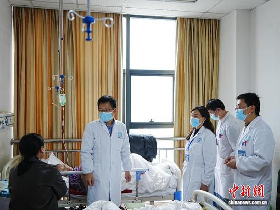 图为重庆市人民医院挂职赫章县人民医院副院长温德容(中)跟着医生在病房查房。记者 周燕玲 摄