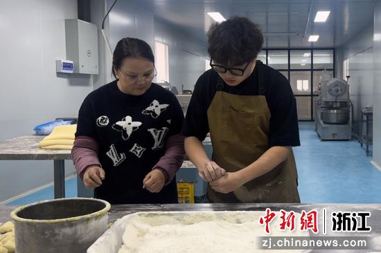 赵陈昌(右一)与母亲赵世华(左一)在工坊内制作烧饼。(资料图,浙江开放大学供图) 赵陈昌(右一)与母亲赵世华(左一)在工坊内制作烧饼。(资料图,浙江开放大学供图)