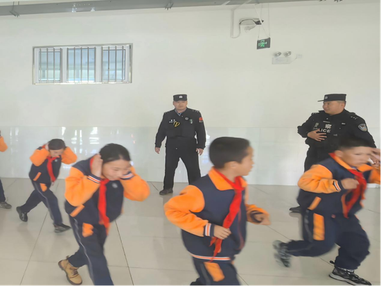 民警正在组织学生开展逃生演练。