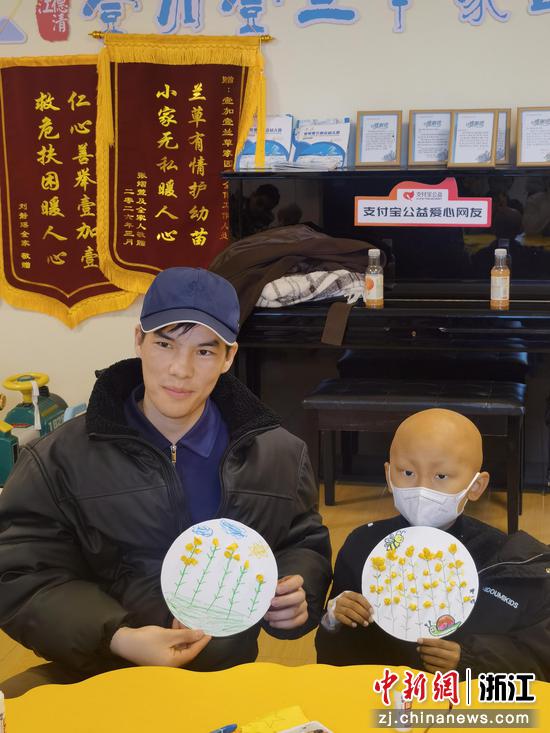 “洋哥”和肿瘤患儿展示自己创作的油菜花作品。王力中 供图 “洋哥”和肿瘤患儿展示自己创作的油菜花作品。王力中 供图