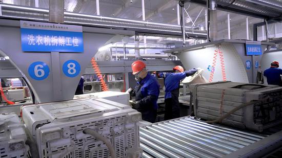 3月30日，在新疆三和生态环境服务有限公司生产车间，一台台废旧家电经过粗拆、破碎、分选等工序，产生的物料将成为汽车、办公设备、包装等领域的再生原料。（沙志浩 摄