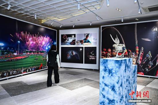 3月30日晚，多彩贵州城原生态文化艺术中心内的摄影作品吸引参会人员。中新社记者 瞿宏伦 摄
