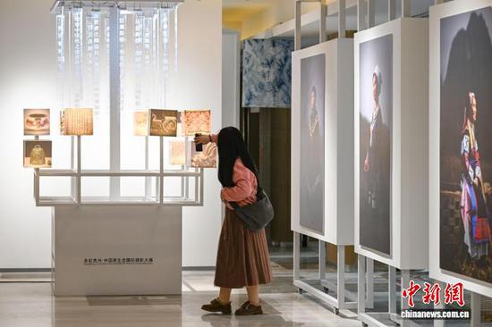 3月30日晚，多彩贵州城原生态文化艺术中心内的摄影作品吸引参会人员。中新社记者 瞿宏伦 摄