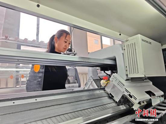 图为3月31日，工人在纺织企业车间的生产线上作业。石小杰  摄