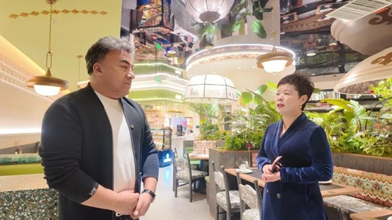 陈玉新（右）与餐饮企业负责人沟通交流。

