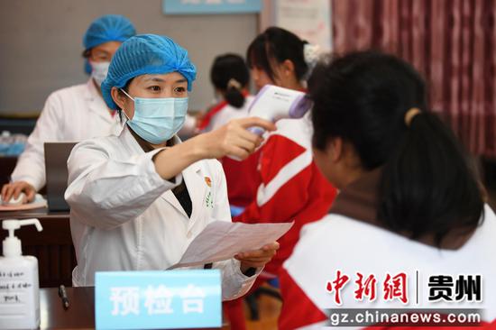 3月31日，贵阳市南明区二戈街道社区卫生服务中心医护人员正为贵阳市第三十九中学适龄女生进行接种前的预检。