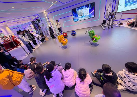 孩子们在“全球首家机器人6S店”贵州首店观看机器狗舞狮表演