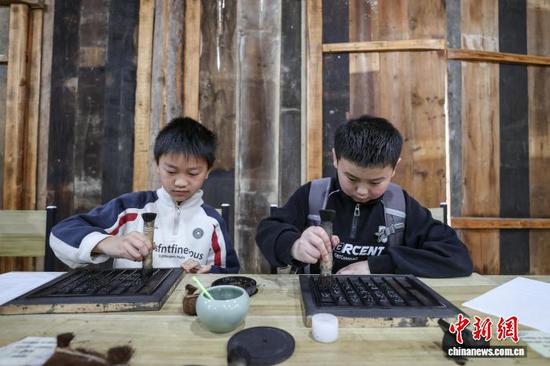 4月1日，贵州省黔南州，学生在贵定县匠人小镇体验活字印刷。当日，贵州中小学生迎来首个春假，为丰富学生假期生活，贵州各地因地制宜推出系列多彩活动，让学生乐享春假时光。中新社记者 瞿宏伦 摄