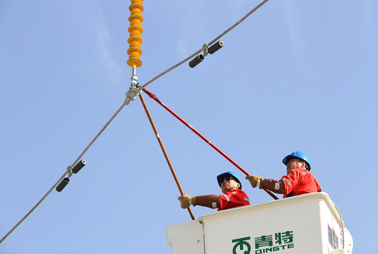 电力公司员工正在进行高空带电作业培训。樊洪 摄