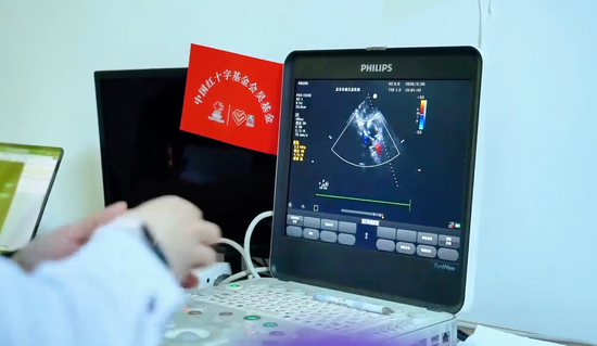 专家团医生在为就诊的孩子做心脏超声检查。