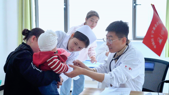 专家团医生正在给患儿听诊。
