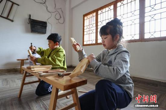 4月1日，贵州省黔南州，学生在贵定县匠人小镇体验榫卯木艺。当日，贵州中小学生迎来首个春假，为丰富学生假期生活，贵州各地因地制宜推出系列多彩活动，让学生乐享春假时光。中新社记者 瞿宏伦 摄
