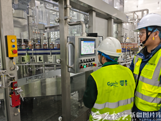3月18日，新疆乌苏啤酒有限责任公司首条1升拉罐啤酒生产线正式投产运行，图为技术人员正在调试生产线参数。石榴云/新疆日报记者刘毅 摄