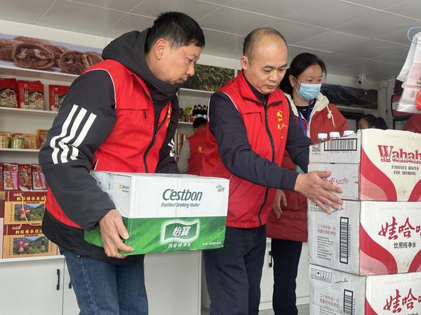 党员在帮助零售户整理店铺货物。黄彩芳 摄