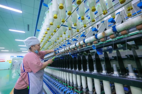 新疆金鑫昱纺织有限责任公司纺织设备高速运转，工人有序作业（资料图）。

