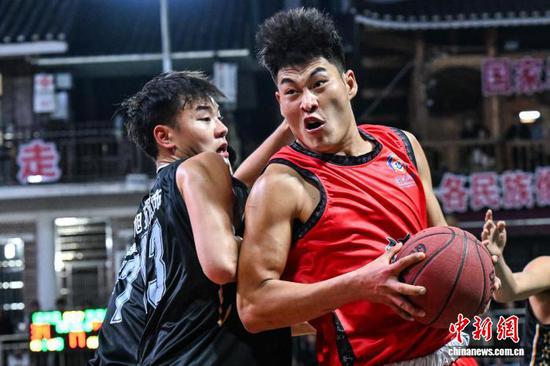 4月11日晚，凯里市代表队(黑衣)和沿河自治县代表队球员在比赛中。中新社记者 瞿宏伦 摄