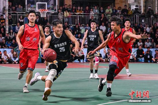 图为凯里市代表队(黑衣)和沿河自治县代表队球员在比赛中。　中新网记者 瞿宏伦 摄