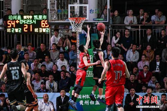4月11日晚，凯里市代表队(黑衣)和沿河自治县代表队球员在比赛中。中新社记者 瞿宏伦 摄