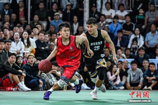 4月11日晚，凯里市代表队(黑衣)和沿河自治县代表队球员在比赛中。中新社记者 瞿宏伦 摄