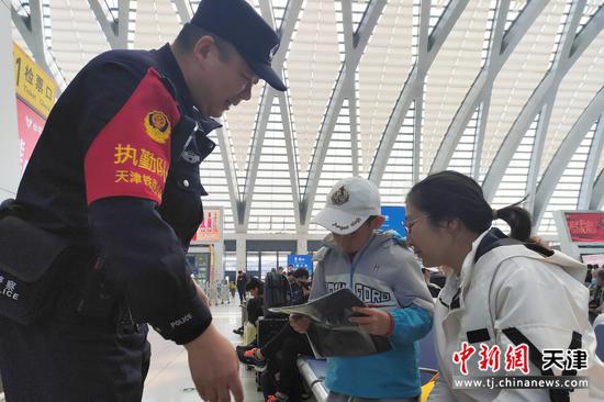 图为北京铁路公安局天津公安处民警正在向候车旅客宣传国家安全知识,提升旅客防范能力。(北京铁路公安局天津公安处供图) 图为北京铁路公安局天津公安处民警正在向候车旅客宣传国家安全知识,提升旅客防范能力。(北京铁路公安局天津公安处供图)