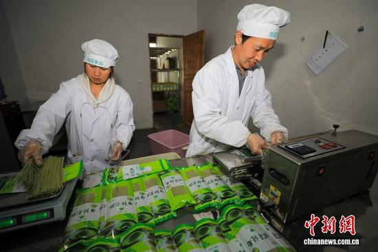 图为工人在铜仁市江口县一家食品加工企业包装抹茶面条。李鹤摄 图为工人在铜仁市江口县一家食品加工企业包装抹茶面条。李鹤摄