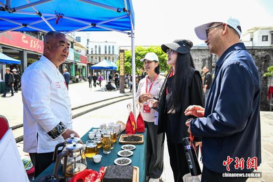 4月18日，制茶大师向参观者介绍黄茶制作工艺。中新社记者 瞿宏伦 摄