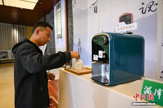 4月18日，工作人员在茶博会现场使用“AI泡茶机器人”泡茶。中新社记者 瞿宏伦 摄