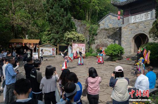 4月18日，2026“国际文旅体验官探秘贵州”参访团走进贵州省安顺市云峰屯堡，近距离感受屯堡文化魅力。参访团由来自老挝、越南、马来西亚、泰国、柬埔寨、菲律宾、印度尼西亚等东南亚部分国家和地区的主流媒体记者、自媒体博主及旅行社代表组成。在云峰屯堡，参访团观看了屯堡地戏表演，走访石头民居，了解屯堡建筑与生活方式，并品尝当地特色小吃。通过实地参访，进一步加深了对贵州历史文化和文旅资源的认识。图为参访团在云峰屯堡观看地戏表演。唐哲 摄
