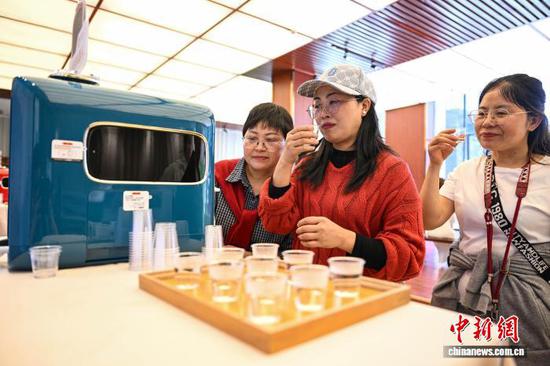 4月18日，参观者在茶博会现场品茗“AI泡茶机器人”泡的茶。中新社记者 瞿宏伦 摄
