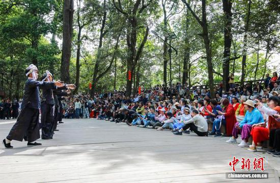 图为游客在岜沙苗寨观看民俗表演。罗京来 摄