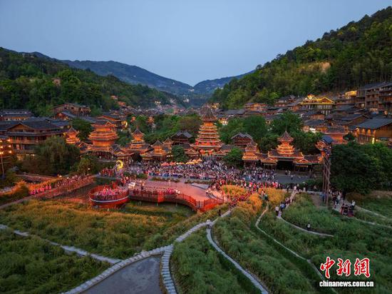 4月18日，游客在贵州省黎平县肇兴侗寨观看侗族大歌。龙建睿 摄