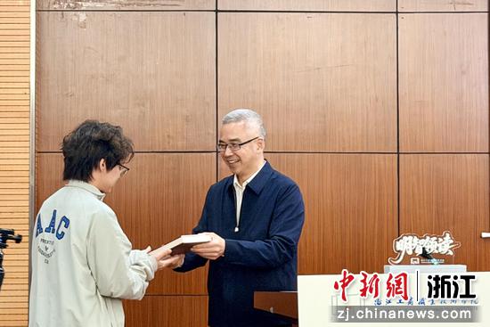 近日，史习明向学生赠书。（主办方供图）