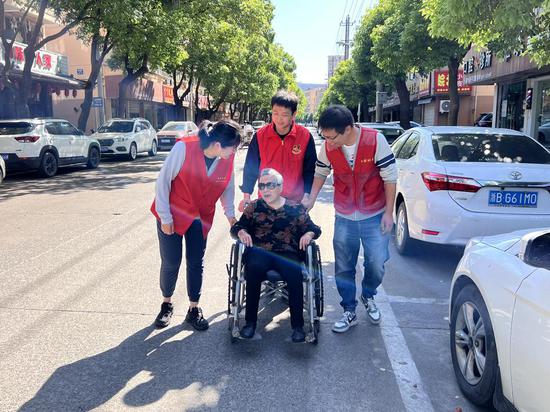 志愿者将腿脚不便的老人送医.jpg