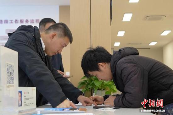 工作人员协助咨询者填写相关材料。吴君毅 摄 工作人员协助咨询者填写相关材料。吴君毅 摄