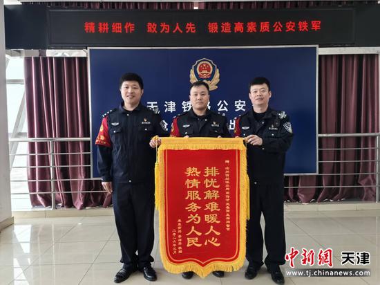 图为沧州西站派出所民警接受旅客赠送的锦旗（北京铁路公安局天津公安处供图）