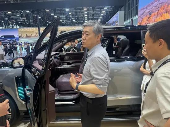 李稻葵在北京车展上试车。国是直通车 陈昊星 摄