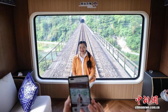 图为旅客在多彩贵州号旅游专列多功能观光车内拍照。