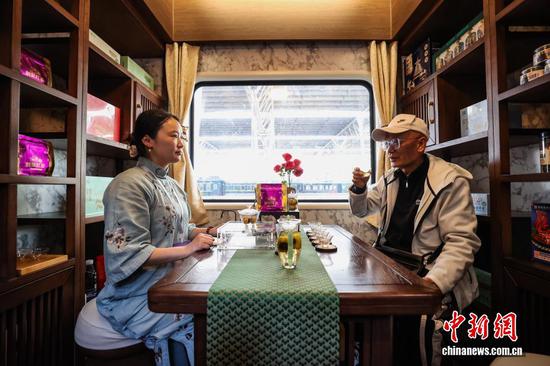 图为旅客在多彩贵州号旅游专列多功能娱乐车内品茗。