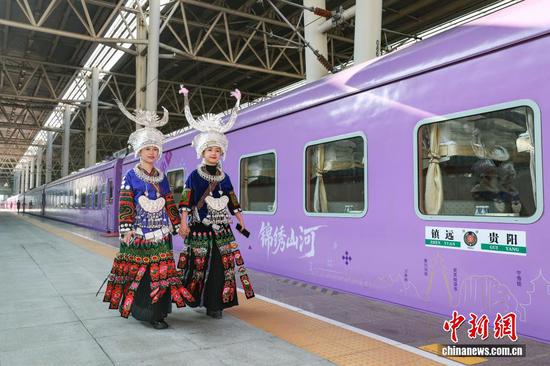 图为穿着民族服装的演员经过多彩贵州号旅游专列。
