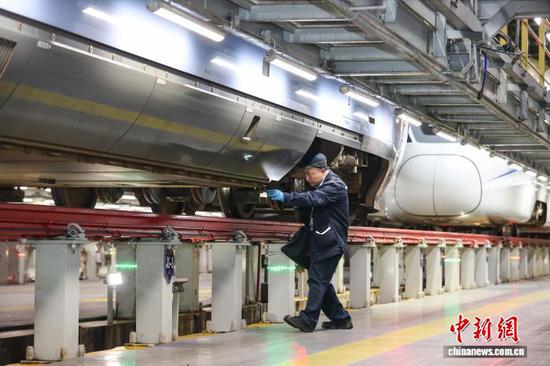 5月1日凌晨，动车机械师在检查“复兴号”动车组列车。中新社记者 瞿宏伦 摄
