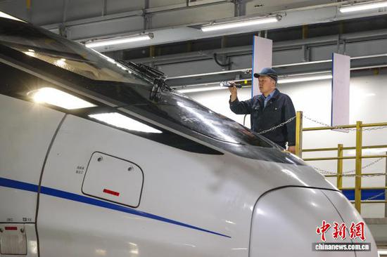 5月1日凌晨，动车机械师在检查动车组车头。当日，正值“五一”国际劳动节，位于贵阳市白云区的贵阳车辆段贵阳北动车运用所内，各个工种的动车机械师坚守在岗位上，对配属的动车组进行检修维护，保障五一假期旅客出行安全。中新社记者 瞿宏伦 摄