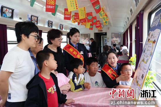 图为:乘务员为旅客推介沿途景点。中新社发 朱秦予 供图 图为:乘务员为旅客推介沿途景点。中新社发 朱秦予 供图